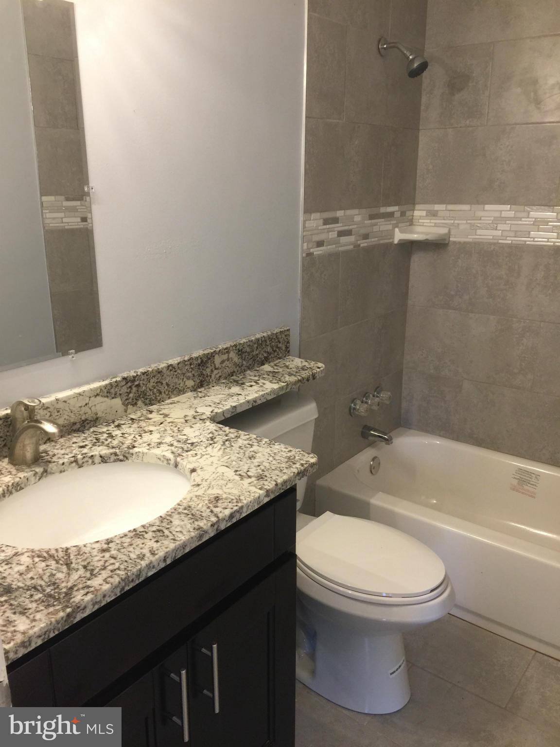 205 Biddle Road Accokeek, MD 20607 - Photo 13 of 24 a bathroom with a granite countertop sink toilet and shower