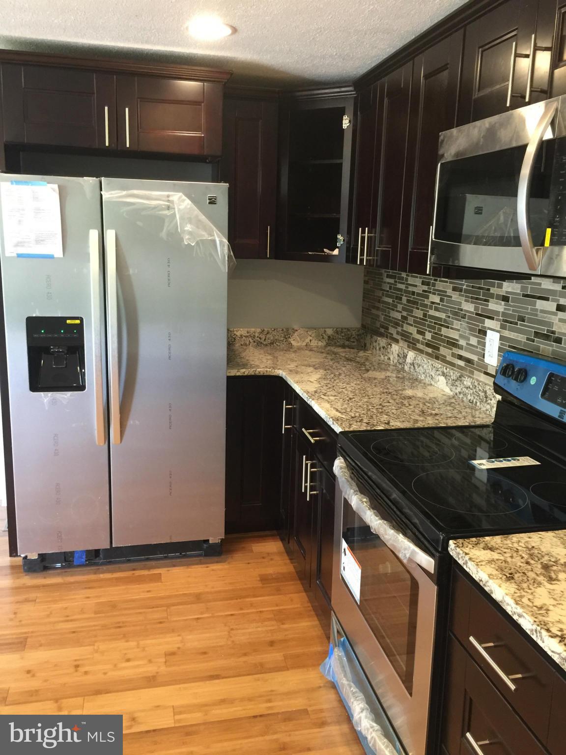 205 Biddle Road Accokeek, MD 20607 - Photo 3 of 24 a kitchen with stainless steel appliances granite countertop a sink stove and microwave