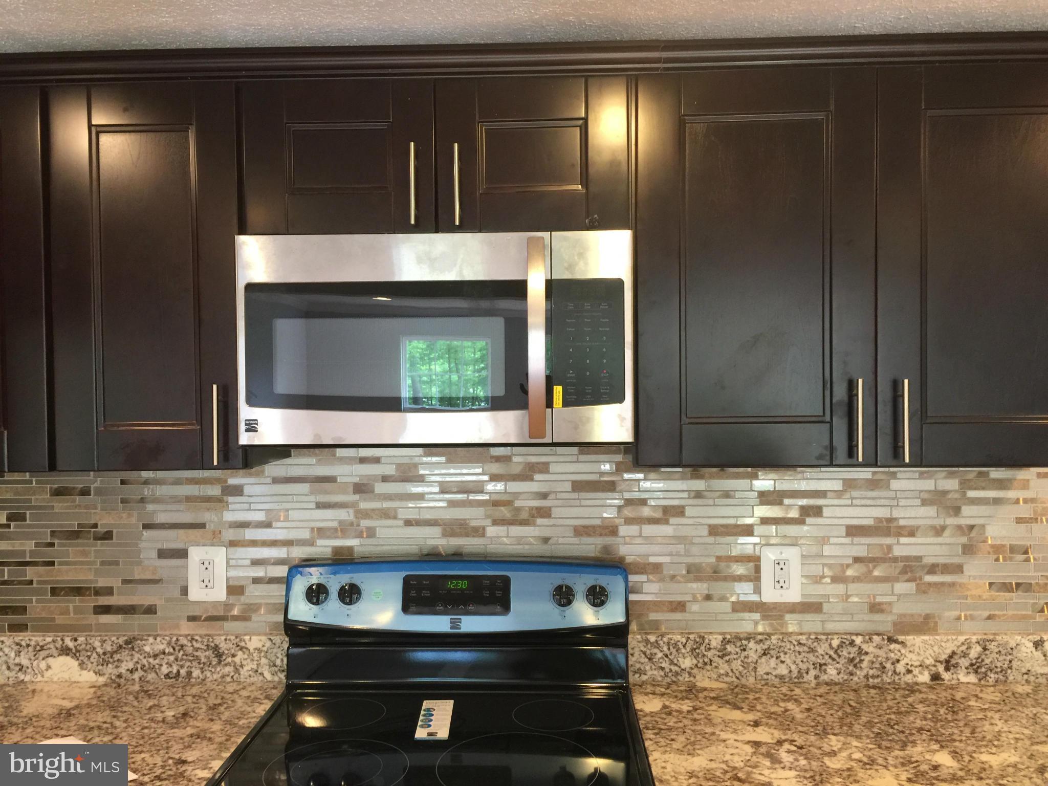 205 Biddle Road Accokeek, MD 20607 - Photo 5 of 24 a kitchen with a stove and a microwave