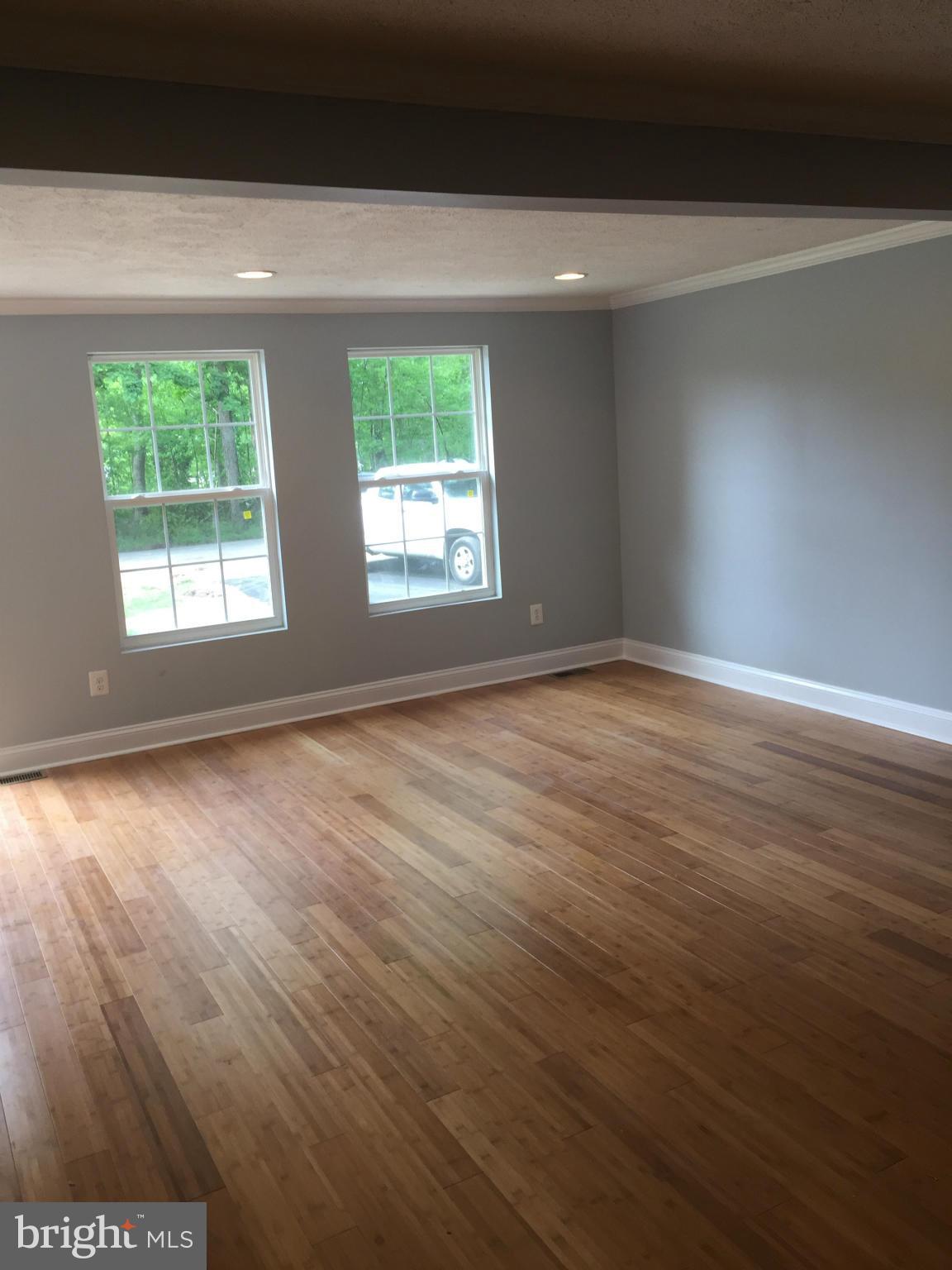 205 Biddle Road Accokeek, MD 20607 - Photo 7 of 24 an empty room with wooden floor and windows