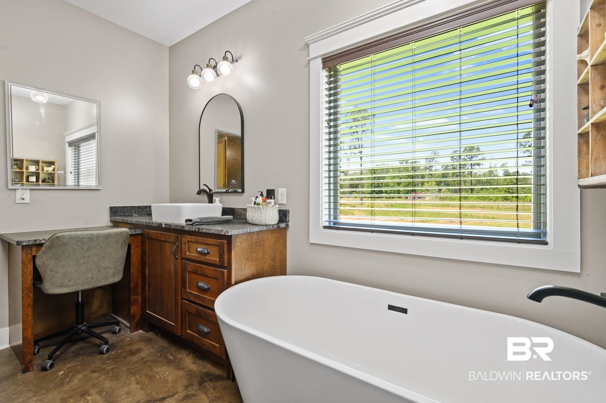 11025 Creax Road Axis, AL 36505 - Photo 25 of 45 Freestanding soaking tub with dark finish wall-mounted faucet, complemented by a wood-finish vanity with a vessel sink and stone-look countertop