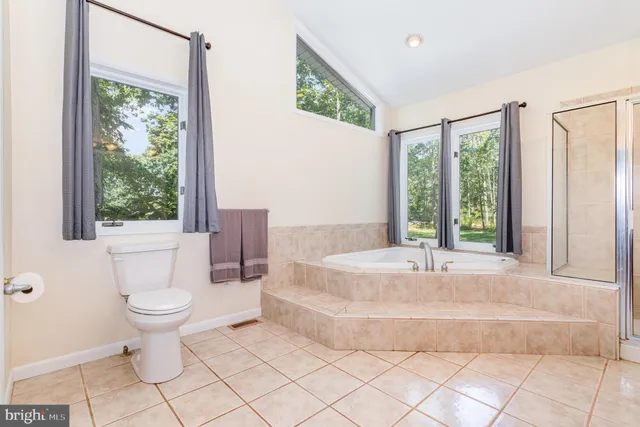 a bathroom with a sink a toilet a mirror and a tub