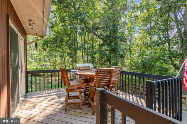 a view of a balcony with wooden floor and outdoor seating