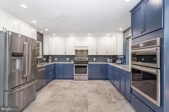 a large kitchen with a refrigerator and a stove top oven