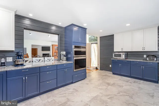 a kitchen with stainless steel appliances granite countertop a stove refrigerator and cabinets