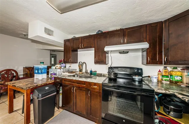 a kitchen with stainless steel appliances a stove a sink dishwasher and cabinets with wooden floor