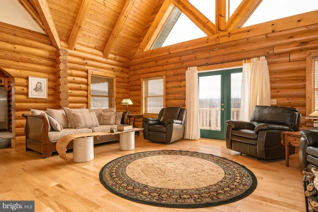 a dining room with furniture large windows and wooden floor