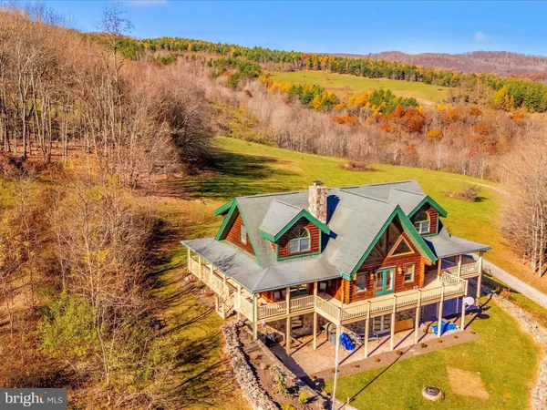a view of a house with a big yard and large trees