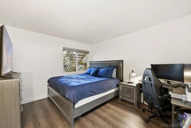 a bedroom with a bed tv and a window