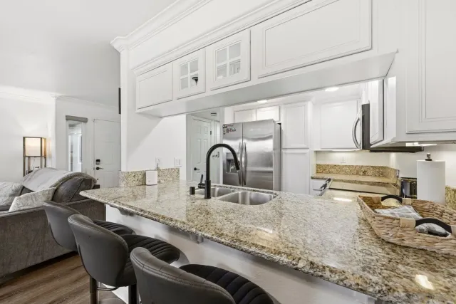 a kitchen with kitchen island granite countertop a sink and wooden cabinets