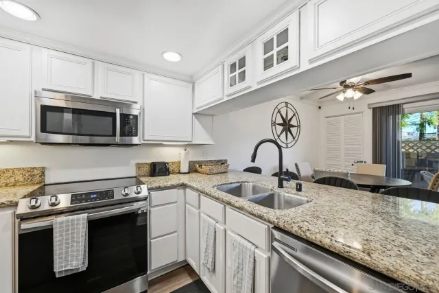 a kitchen with stainless steel appliances granite countertop a sink and a stove