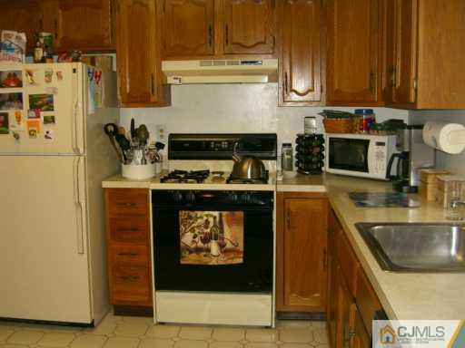 704 Timber Oaks Road Edison, NJ 08820 - Photo 8 of 8 a kitchen with stainless steel appliances a stove a microwave and a sink
