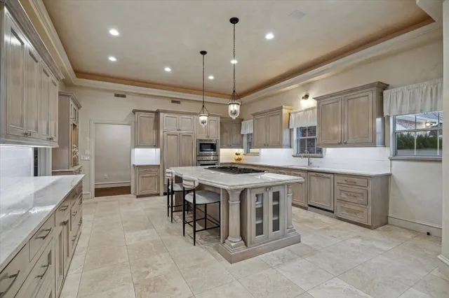 a kitchen with kitchen island a counter top space appliances and a sink