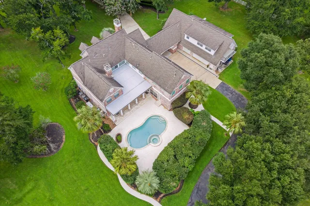 an aerial view of a house with a garden and trees