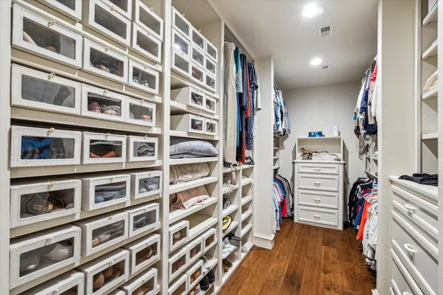 a view of walk in closet with clothes and shoes
