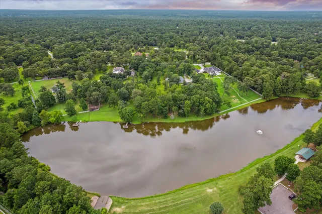 an aerial view of a house with a yard and lake view