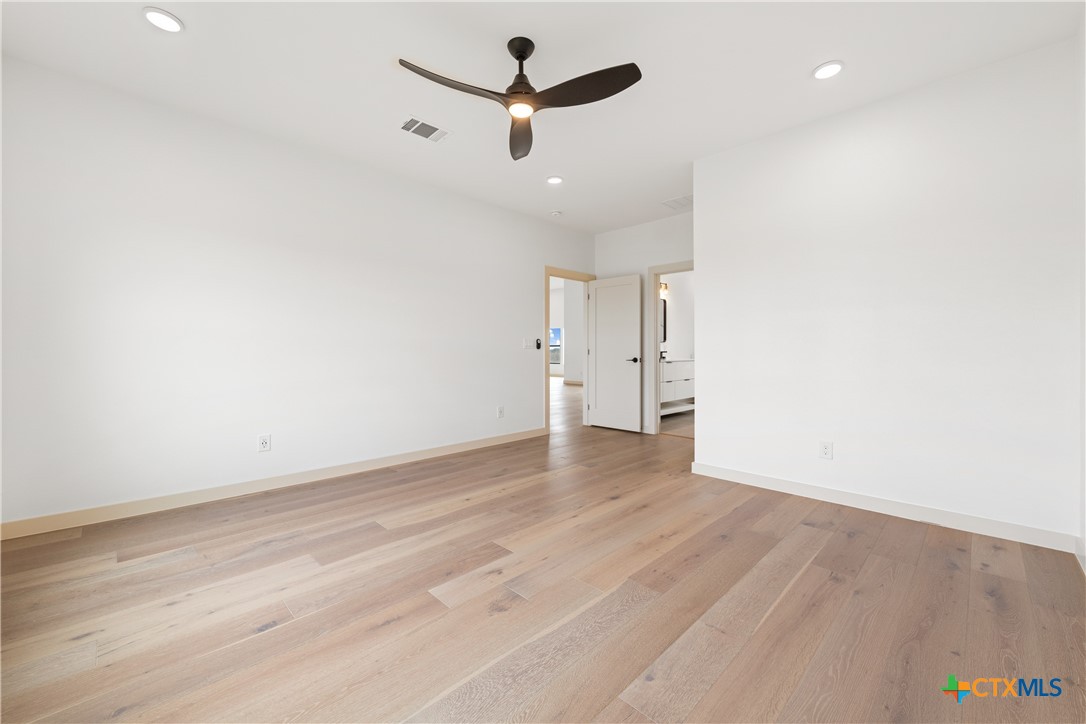 15121 Armstrong Ests Road Salado, TX 76571 - Photo 16 of 45 an empty room with a ceiling fan and wooden floor