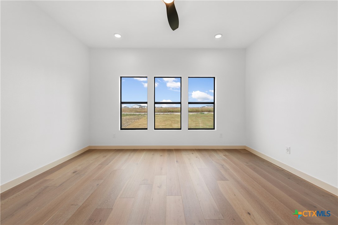 15121 Armstrong Ests Road Salado, TX 76571 - Photo 17 of 45 an empty room with wooden floor and windows