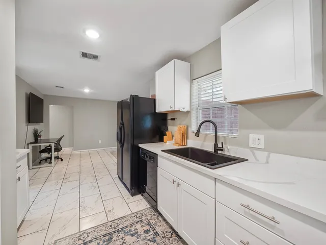 a kitchen with a sink appliances and cabinets