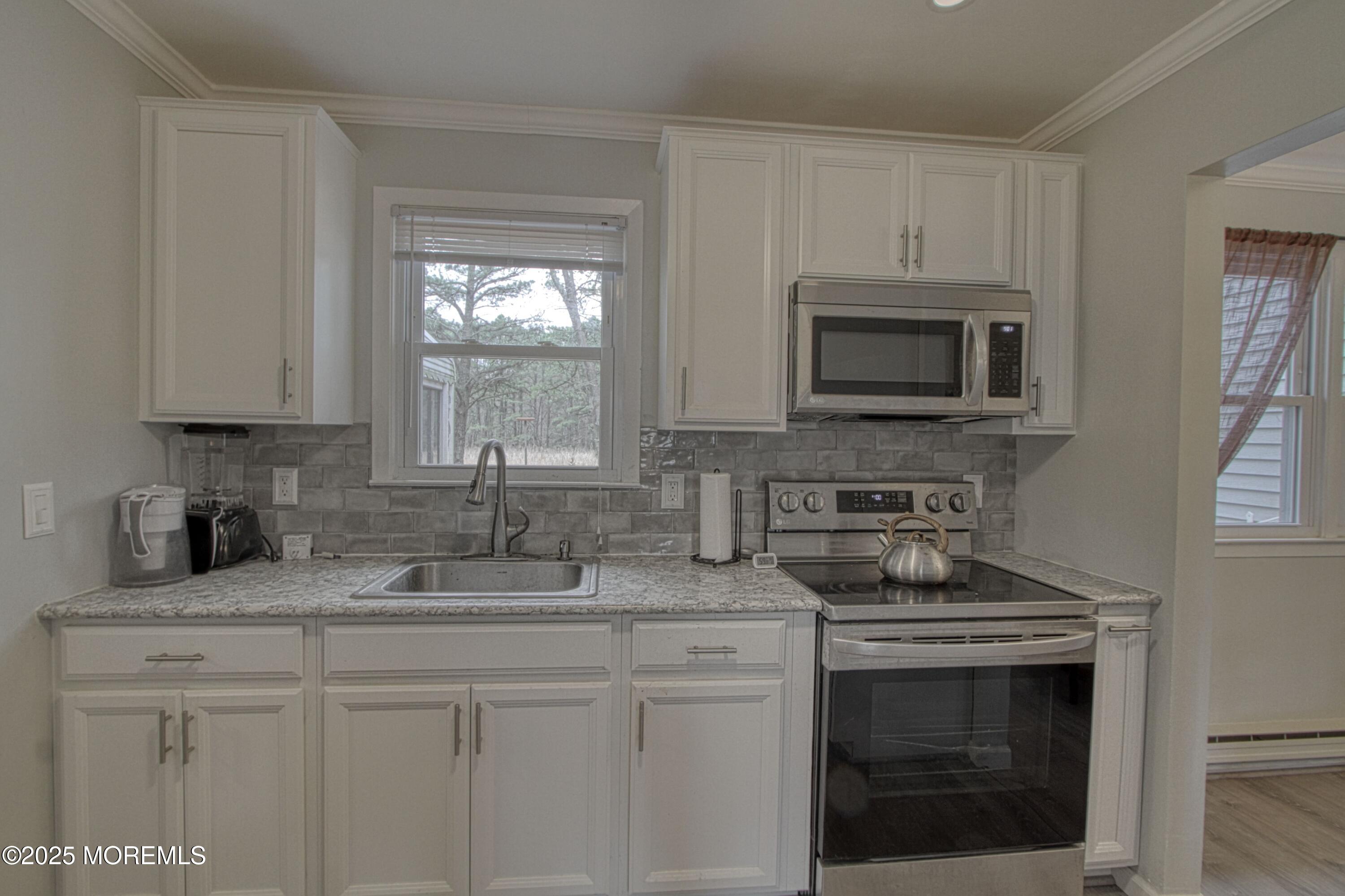 32 Augusta Road Whiting, NJ 08759 - Photo 4 of 30 a kitchen with granite countertop white cabinets appliances a sink and a window