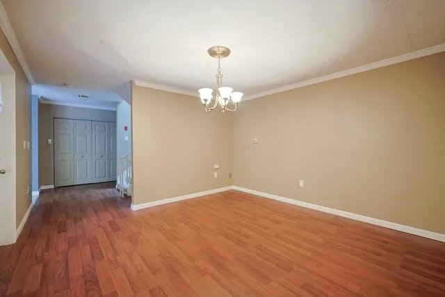 a view of an empty room with wooden floor and a fireplace