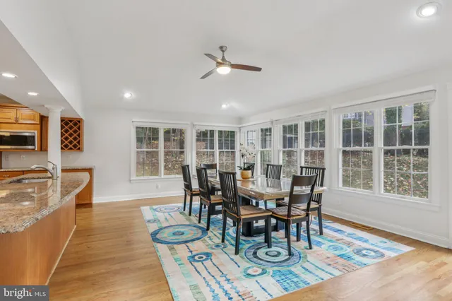 a large kitchen with stainless steel appliances granite countertop plenty wooden cabinets and wooden floor