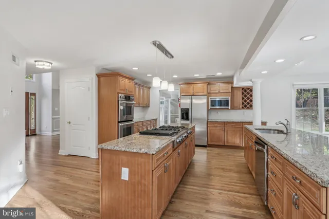 a kitchen with stainless steel appliances granite countertop a stove a sink and a refrigerator
