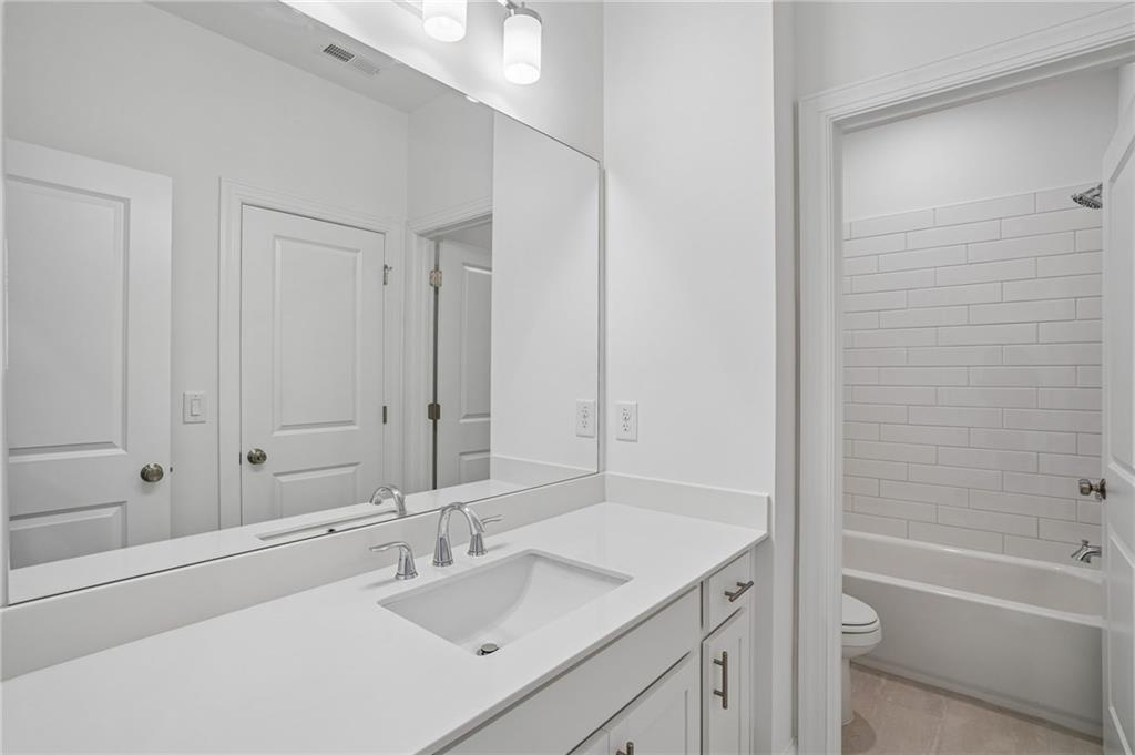 1502 Westend Way, Unit 331 Cumming, GA 30041 - Photo 20 of 38 a bathroom with a granite countertop sink a toilet and shower