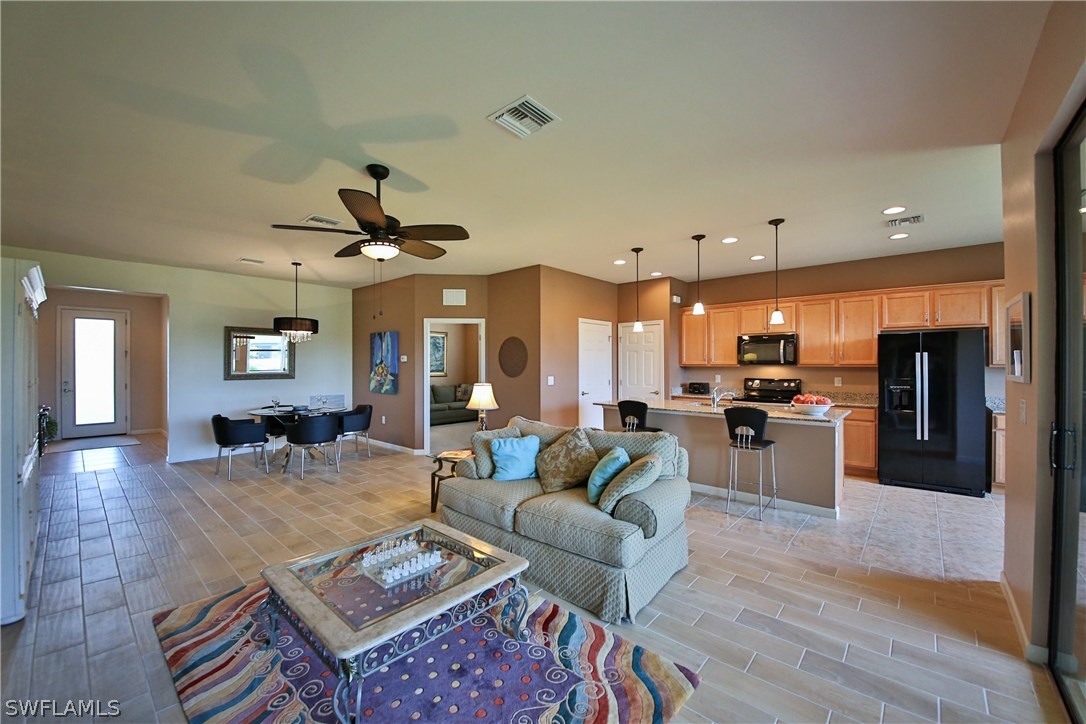 10805 Rutherford Road Fort Myers, FL 33913 - Photo 6 of 25 a living room with furniture kitchen view and a wooden floor