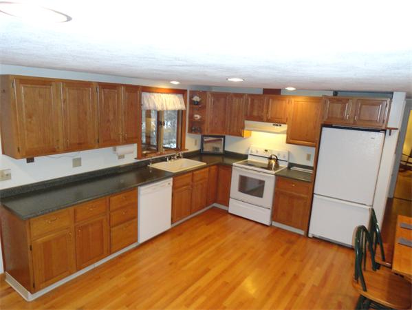 23 Hiley Brook Road Stow, MA 01775 - Photo 4 of 6 a kitchen with granite countertop wooden floors and white stainless steel appliances