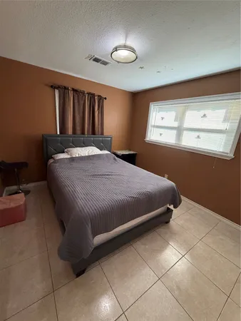 a bedroom with a bed and a window