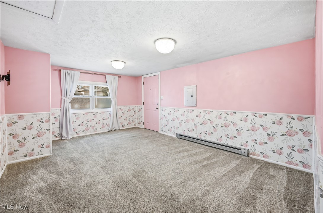 245 North Road Niles, OH 44446 - Photo 24 of 45 Empty room with wallpapered walls, a textured ceiling, a baseboard heating unit, carpet floors, and electric panel
