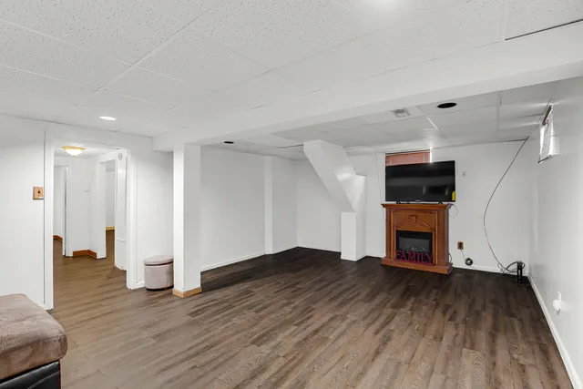 a view of empty room with wooden floor and fireplace