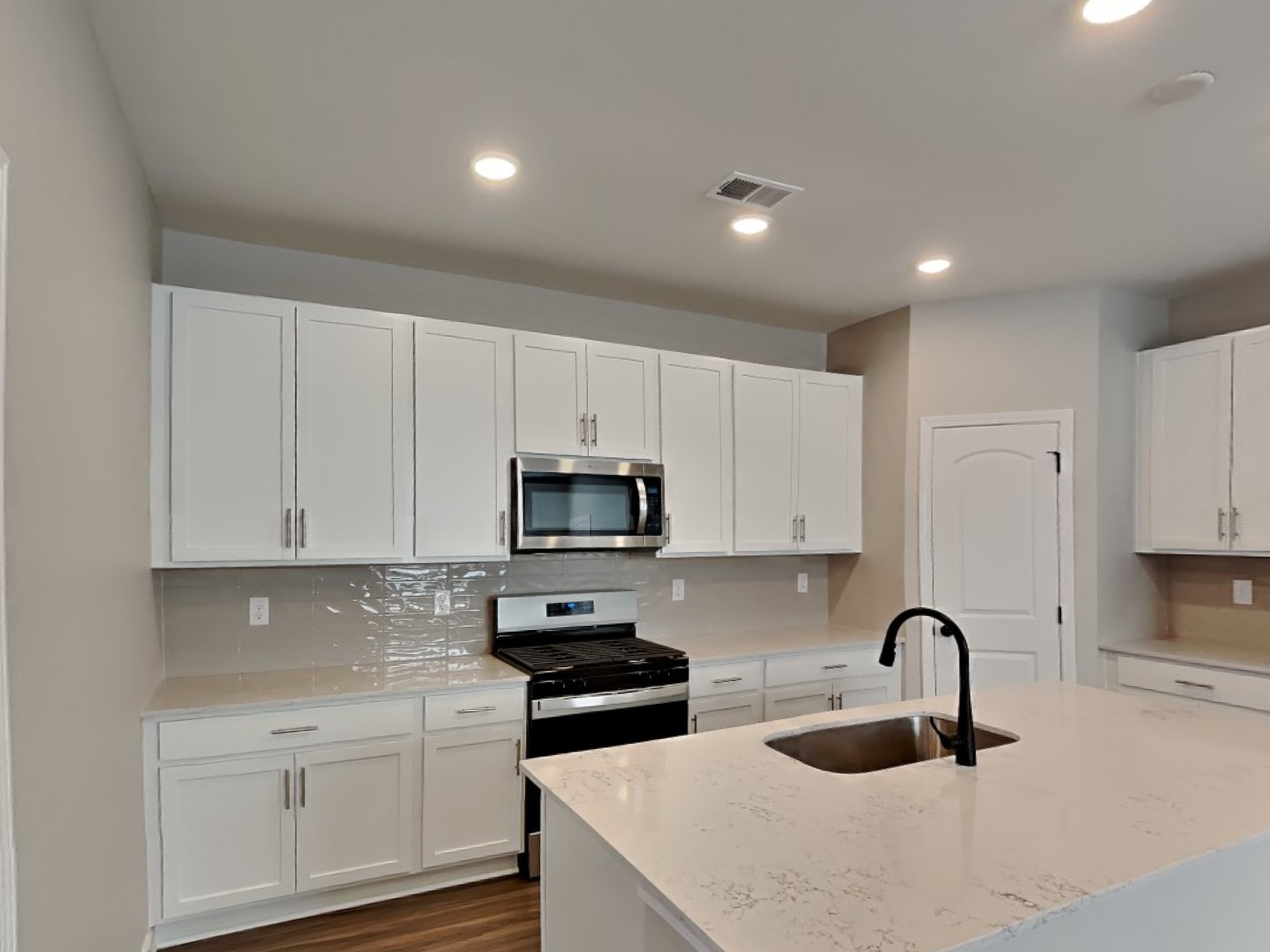 819 Averitt Lane Lebanon, TN 37087 - Photo 4 of 18 a kitchen with stainless steel appliances granite countertop a sink a stove a microwave a refrigerator a stove and white cabinets with wooden floor