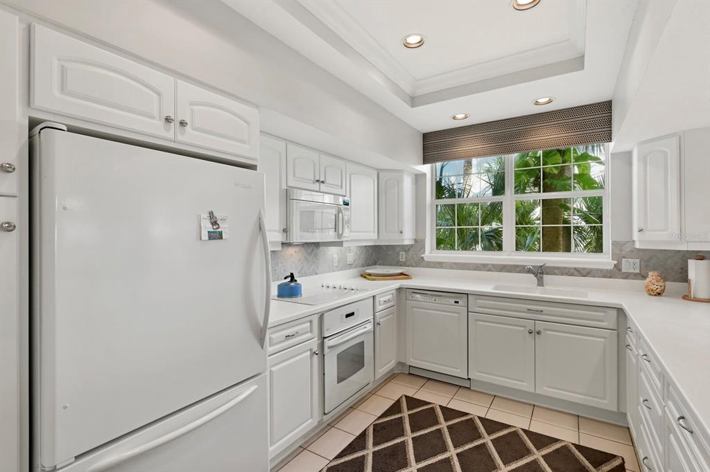 729 South Harbor Drive, Unit 1 Boca Grande, FL 33921 - Photo 13 of 68 a kitchen with a white cabinets and white appliances