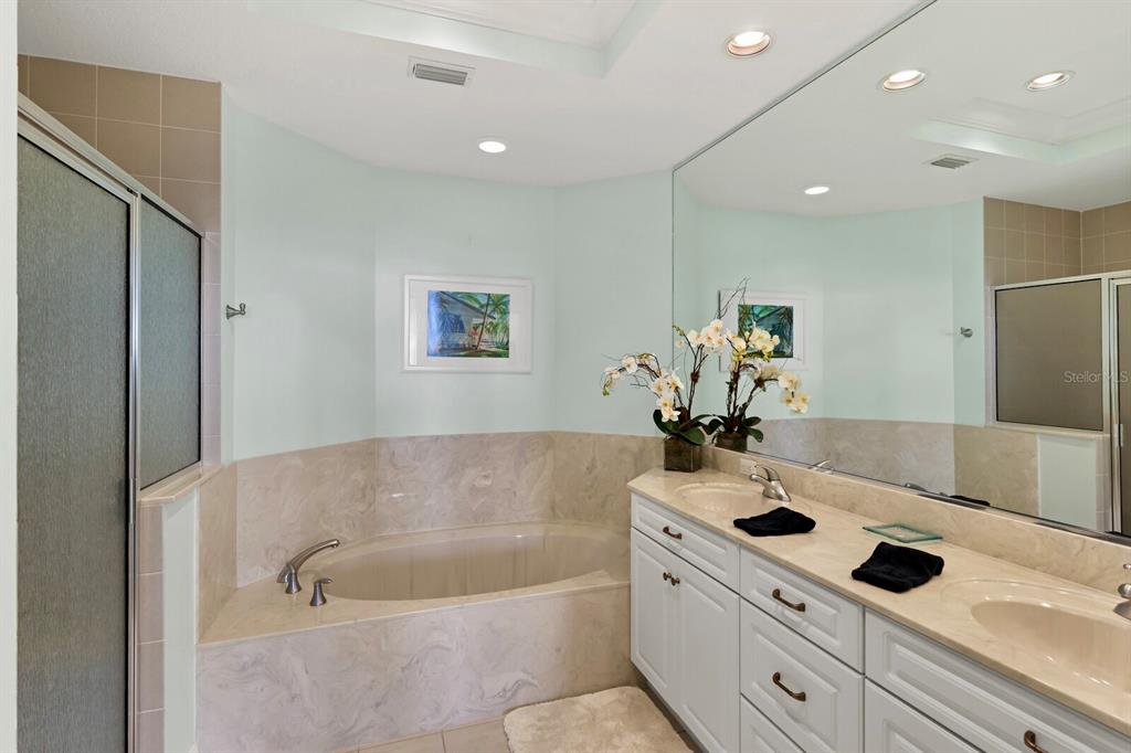 729 South Harbor Drive, Unit 1 Boca Grande, FL 33921 - Photo 9 of 68 a bath tub sitting next to a white sink a vanity and a potted plant