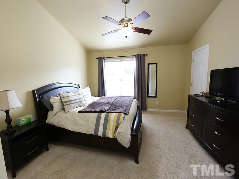 5317 Echo Ridge Road Raleigh, NC 27612 - Photo 11 of 17 a bedroom with a bed and a flat tv screen on dresser