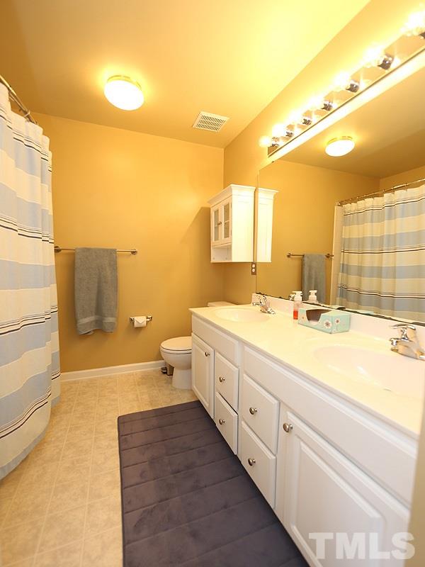 5317 Echo Ridge Road Raleigh, NC 27612 - Photo 12 of 17 a spacious bathroom with a double vanity sink a mirror and a bathtub