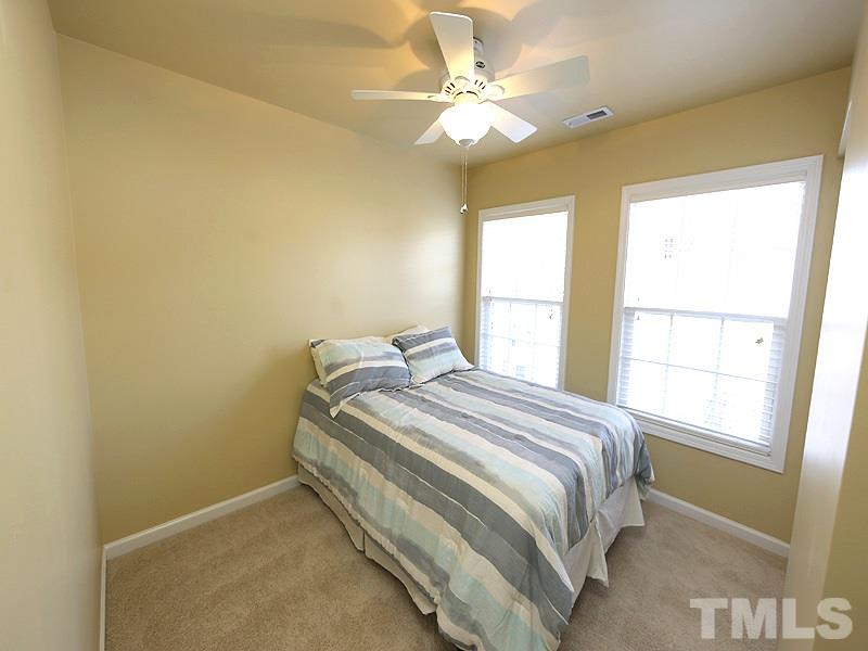 5317 Echo Ridge Road Raleigh, NC 27612 - Photo 14 of 17 a bedroom with a bed and a chandelier