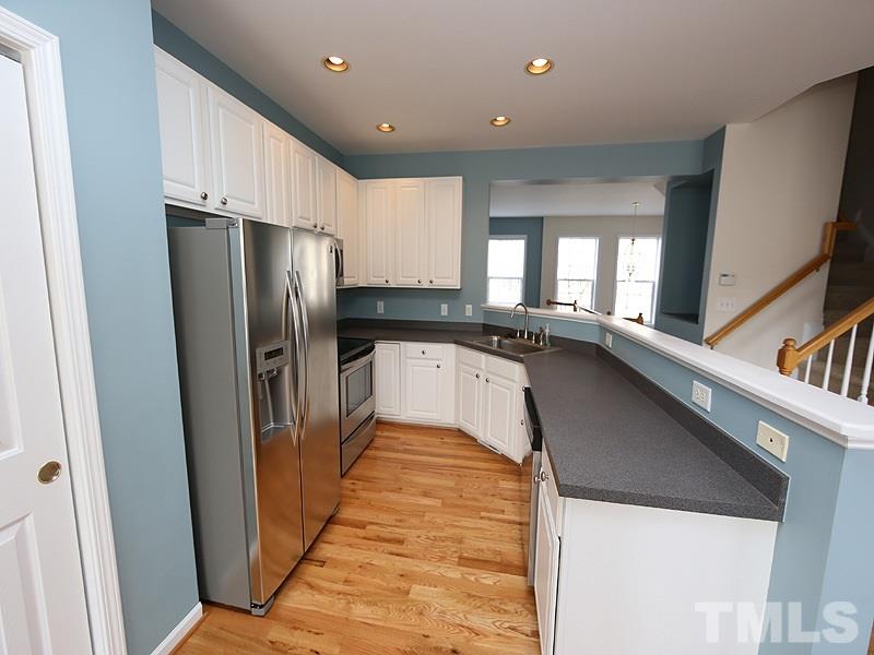 5317 Echo Ridge Road Raleigh, NC 27612 - Photo 7 of 17 a kitchen with granite countertop a refrigerator and a sink
