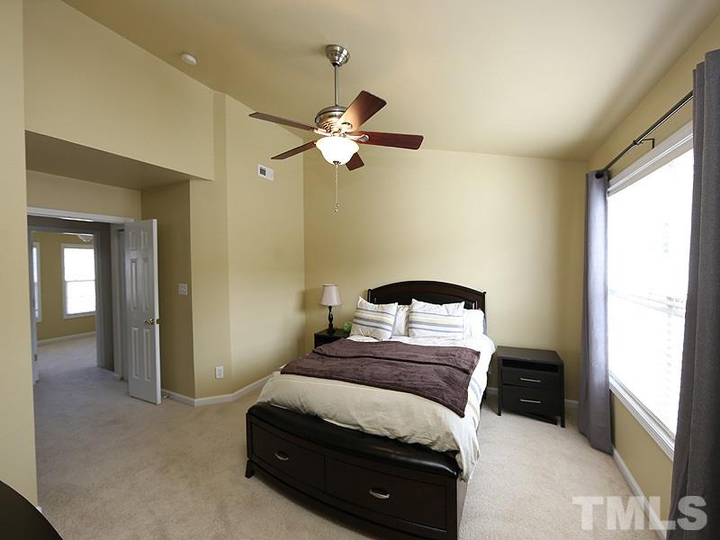 5317 Echo Ridge Road Raleigh, NC 27612 - Photo 10 of 17 a bedroom with a bed and a chandelier