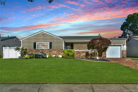 a front view of a house with a garden