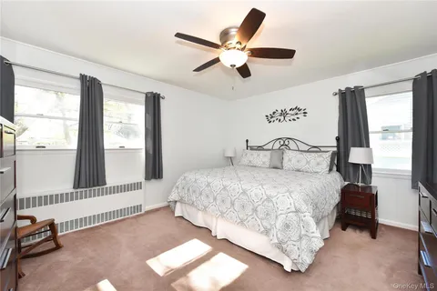 a bedroom with a bed and a large window with the outer view