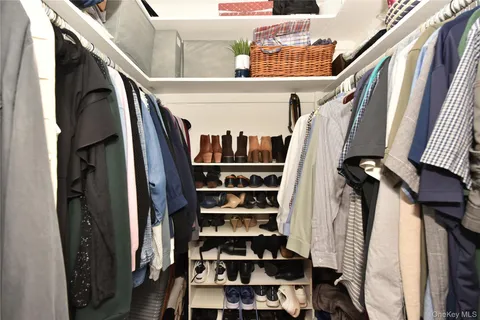 a view of walk in closet with clothes and shoes