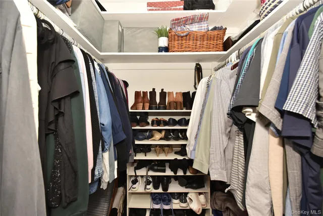 a view of walk in closet with clothes and shoes