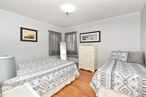 a bedroom with a bed and a lamp on dresser