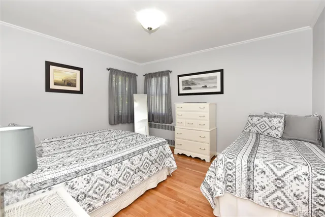 a bedroom with a bed and a lamp on dresser