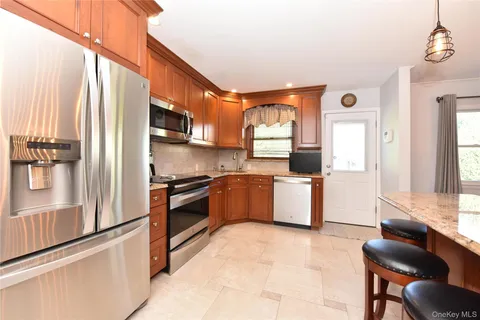 a kitchen with stainless steel appliances kitchen island granite countertop a stove and a refrigerator