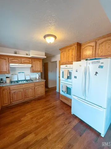 a kitchen with stainless steel appliances wooden floor and large cabinets