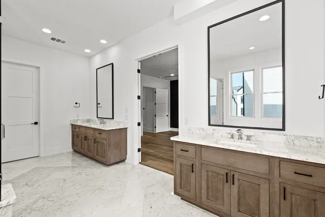 a spacious bathroom with double vanity sink a mirror and a bathtub